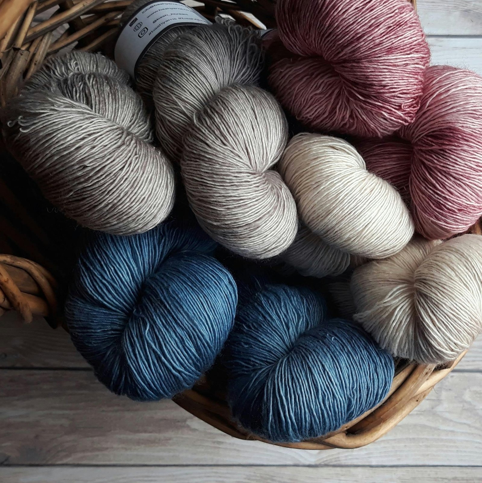 A collection of colorful yarn skeins in a basket, perfect for knitting and crafting projects.